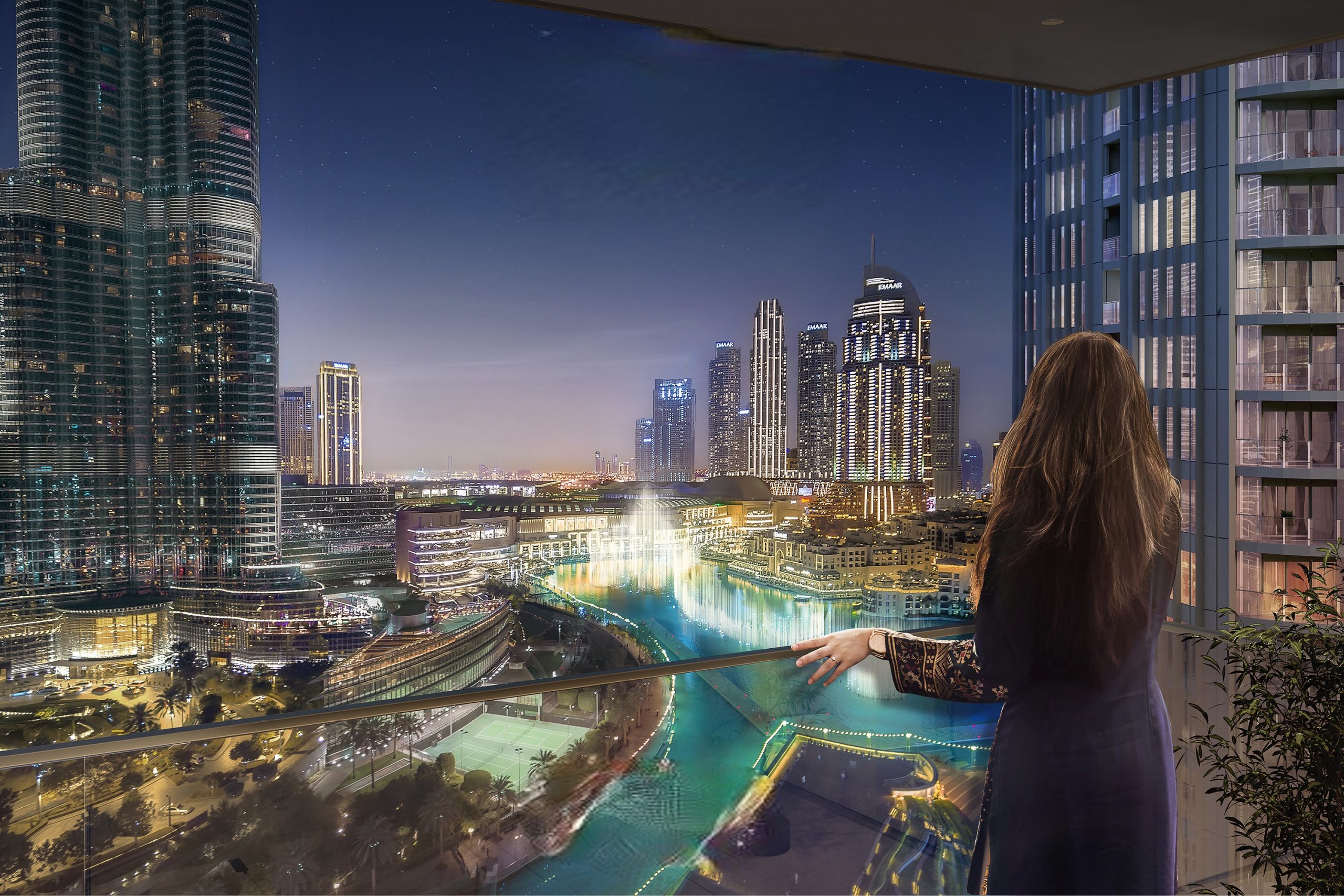 An elegant lady admires the cityscape under the night sky at St. Regis Residences Downtown Dubai.
